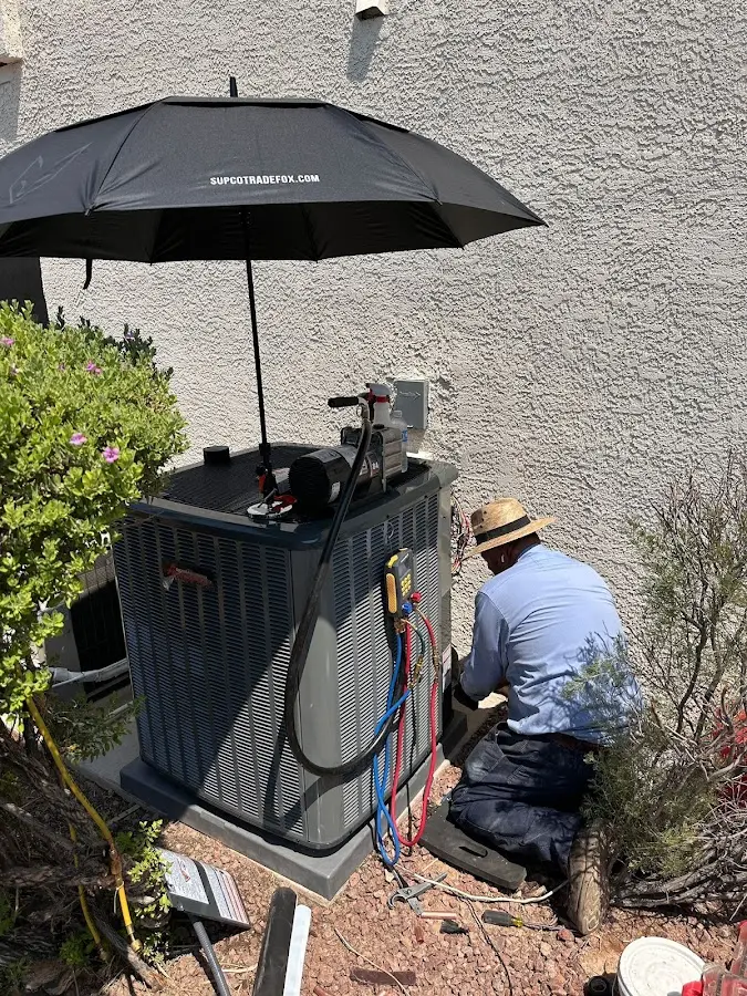 HVAC technician performing outdoor AC maintenance in Baldwin City