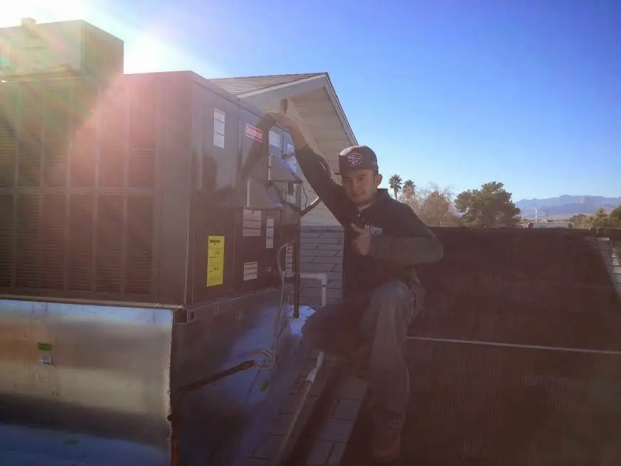 HVAC technician performing AC Tune-Up on a rooftop unit in Baldwin City